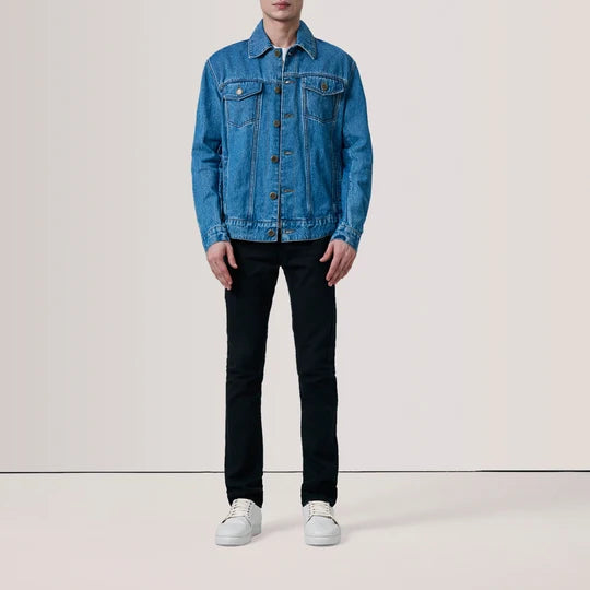 Full body view of men's blue denim trucker jacket paired with black jeans