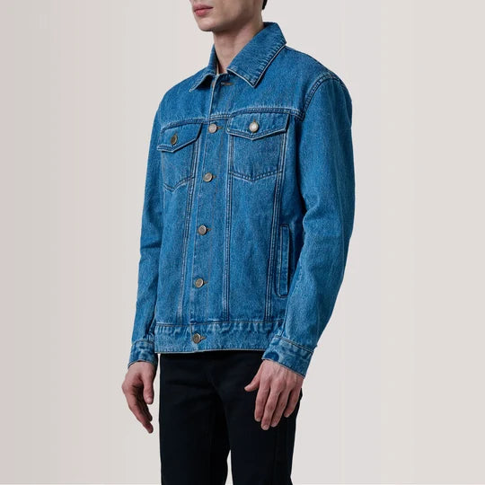 Full body view of men's blue denim trucker jacket paired with black jeans