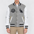 Men’s grey wool varsity jacket with white leather sleeves, striped rib trim, snap front and embroidered patches