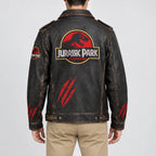 Men's Jurassic Park distressed black leather jacket featuring a large red and yellow back logo, red claw marks, sleeve patches, and vintage brown detailing.