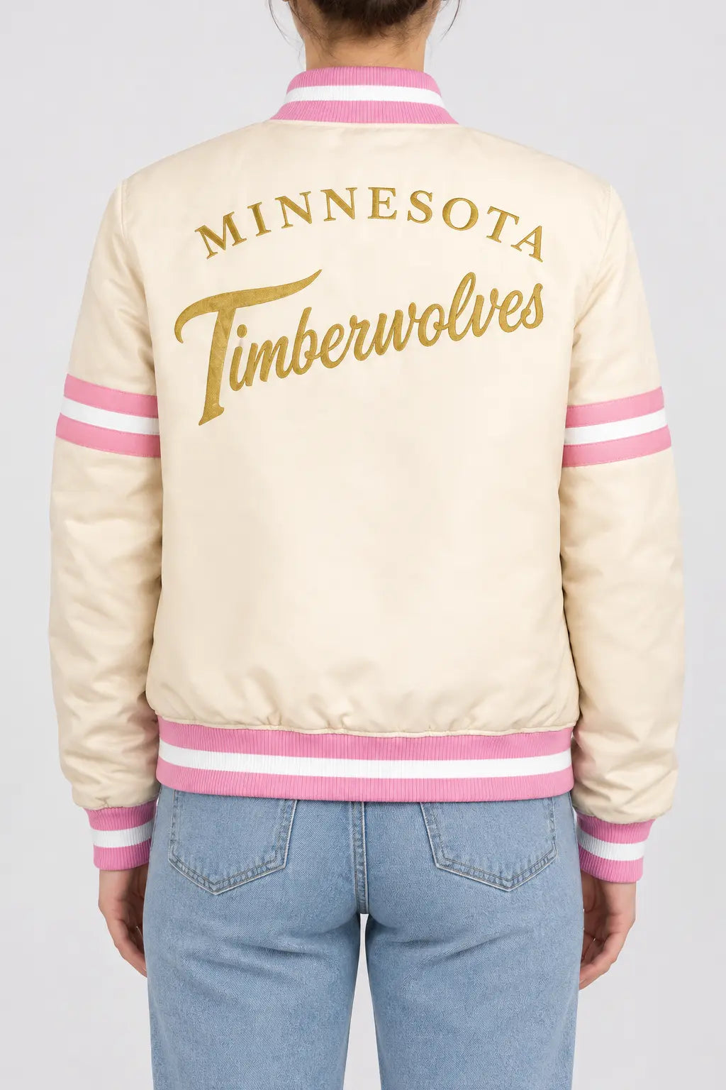 Women’s cream satin full-snap varsity jacket with gold script lettering across the back and pink striped rib trim