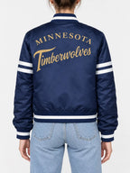 Women’s navy blue satin full-snap varsity jacket with gold script lettering across the back and white sleeve stripes
