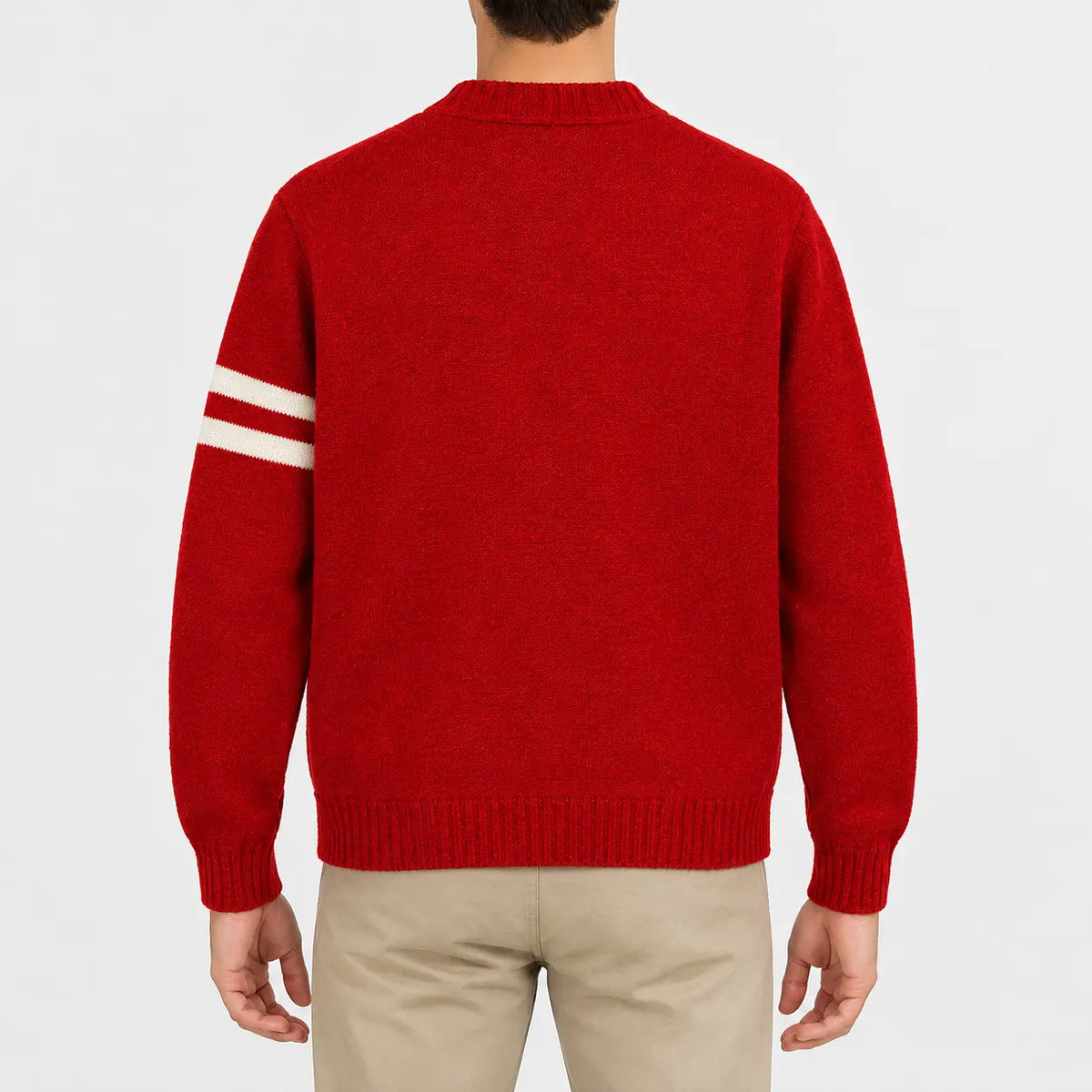 Men's red knit cardigan jacket featuring a skull and crossbones patch, cream sleeve stripes, button front closure, ribbed cuffs and hem, styled with khaki chinos.